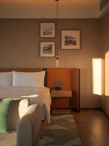 a bedroom with a bed and a chair in it at Holiday Inn Quanzhou Donghai by IHG in Quanzhou