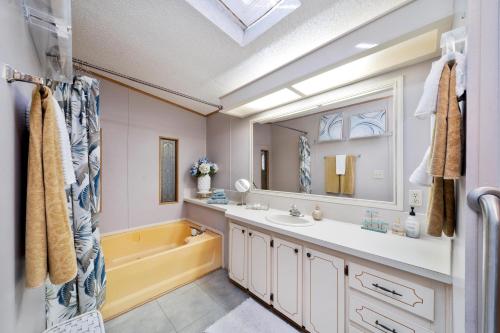 a bathroom with a tub and a sink and a mirror at Lake Accessible Family Home On Canal in Okeechobee