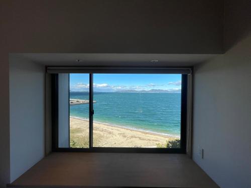 a room with a window looking out at the ocean at SETO CLAS AJI THE SEASIDE HILLS RESORT in Aji