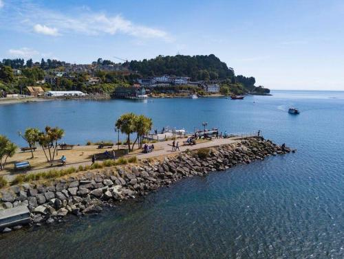 a group of people sitting on a pier in the water at Acogedor Departamento en Zona Residencial in Puerto Varas