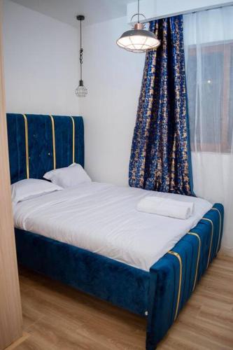 a bedroom with a blue bed with a window at Nairobi City view1 BDRM condo with pool and gym in Nairobi