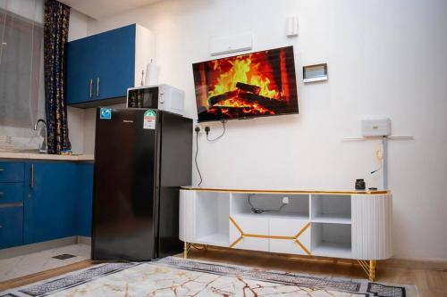 a kitchen with a tv hanging above a refrigerator at Nairobi City view1 BDRM condo with pool and gym in Nairobi