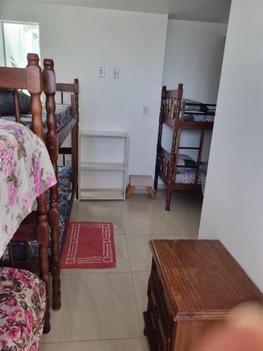 a bedroom with a bed and a table and chairs at Pousada Refugio Paradisíaco 1 in Piçarras