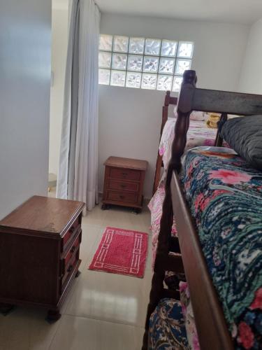 a bedroom with a bed and a dresser and a window at Pousada Refugio Paradisíaco 1 in Piçarras