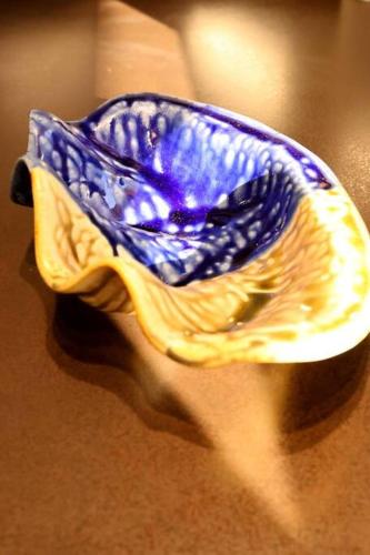 a blue and yellow bowl sitting on a table at Potter House TSUKAMOTO Vue sur Baie de Maroe in HUH