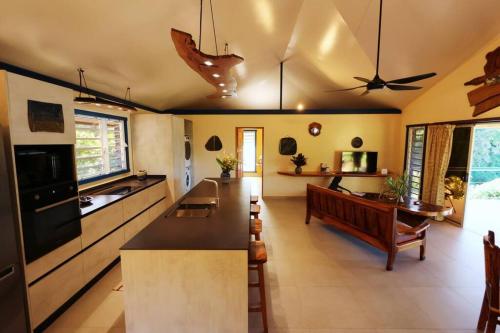 a kitchen with a couch and a table in a room at Potter House TSUKAMOTO Vue sur Baie de Maroe in HUH