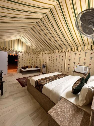 a bedroom with a large bed with a ceiling at DESERT OVERNIGHT LUXURY CAMP & ReSORT in Jaisalmer