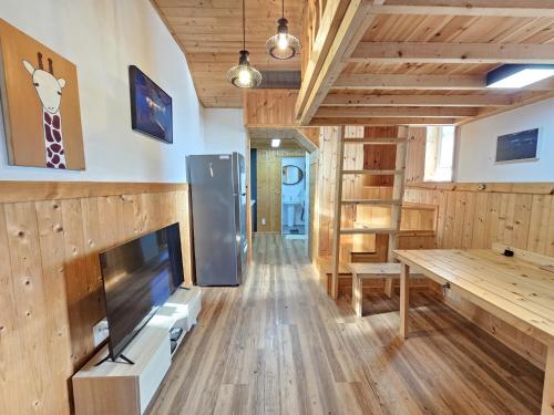 a living room with a tv and a table at Jeju Nova Pension in Jeju