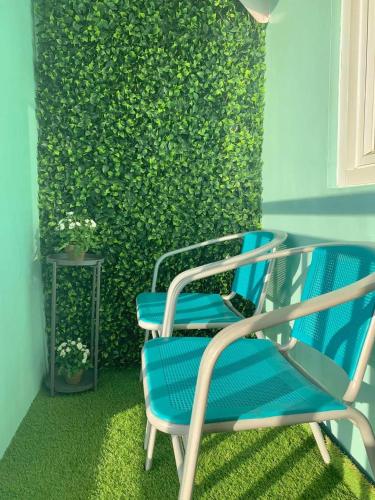 two blue chairs sitting in front of a green wall at Seawind Condominium Near Airport in Davao City