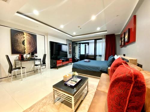 a large living room with a couch and a tv at Patong - Studio Condo - Absolute Bangla Unit in Patong Beach
