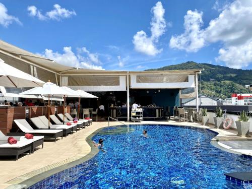 a pool at a hotel with people swimming in it at Patong - Studio Condo - Absolute Bangla Unit in Patong Beach