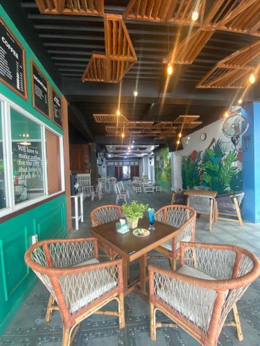 a dining room with a wooden table and chairs at Grand Mahoni Hotel in Banda Aceh