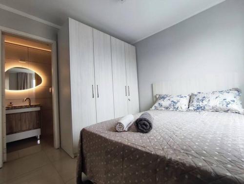 a bedroom with a large bed and a bathroom at Apartamento central in Passo Fundo