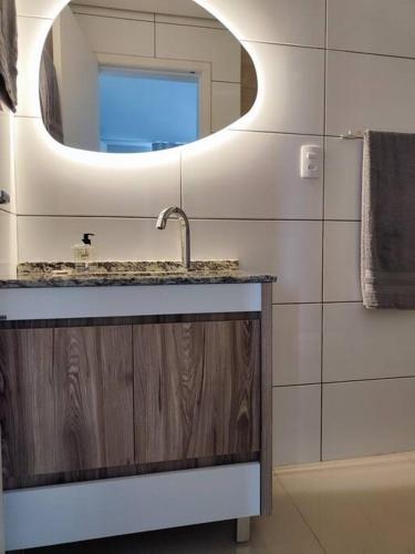 a bathroom with a sink and a mirror at Apartamento central in Passo Fundo