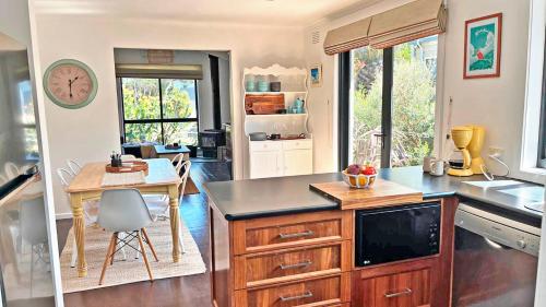 a kitchen with a table and a counter top at Infinity at Surf Beach in Surf Beach