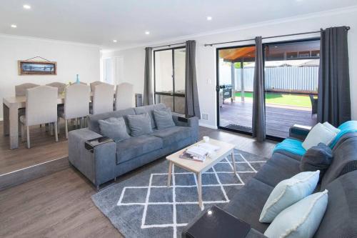 a living room with a couch and a table at 5 Bedroom Home meters from the beach in Geographe