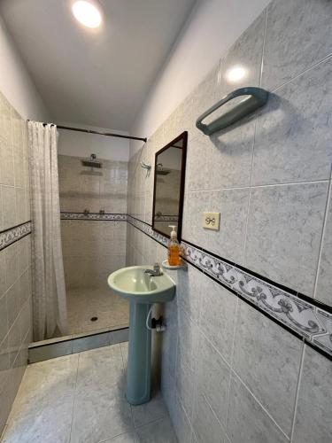 une salle de bain avec un lavabo et une douche dans l'établissement Sandalio Hostal Cali, à Cali