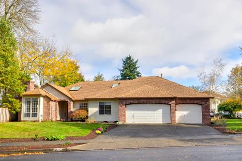 a brick house with two white garage doors at Near Shops and Cafes Beaverton Haven with Luxe Decor! in Beaverton