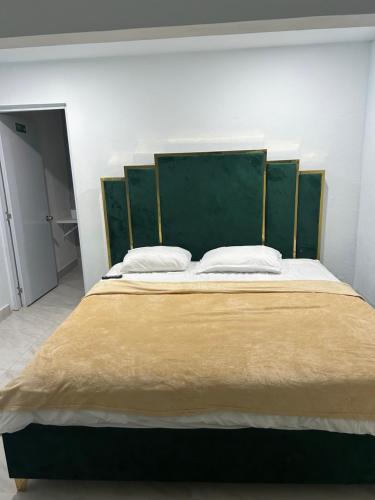 a large bed with a green headboard in a room at Hotel Hannabi in Boca Chica