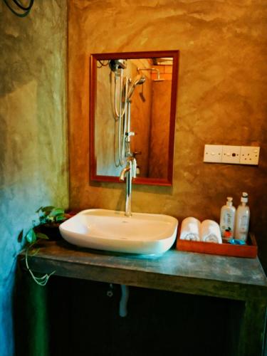 a sink in a bathroom with a mirror at Lunuvila Resort Hiriketiya Dikwella in Dickwella