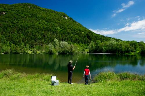 a man and a woman fishing in a lake at Gasthaus Stefaner in Feistritz im Rosental
