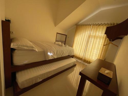 a bedroom with a bed and a window at Bylina House in Batu