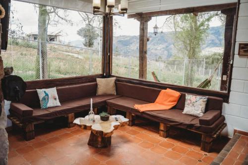 a living room with a couch and a large window at Villa Nathalie, 2 bedrooms, jacuzzi, king size bed, hammock, FIREPLACE in Chicán