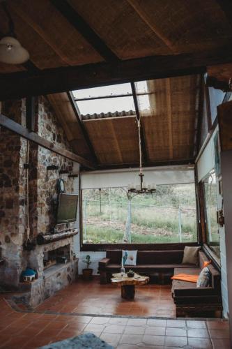 a living room with a couch and a large window at Villa Nathalie, 2 bedrooms, jacuzzi, king size bed, hammock, FIREPLACE in Chicán