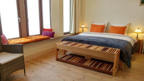 1 dormitorio con cama, banco y ventanas en Bed & Breakfast Exterlaer, en Amberes