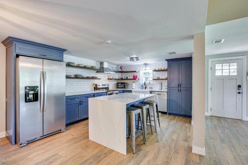 a kitchen with blue cabinets and a refrigerator at Waterfront Retreat with Hot Tub in Gun Barrel City! in Gun Barrel City