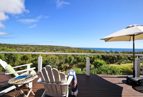 two chairs and an umbrella on a deck at The Whale Lookout, Eagle Bay in Dunsborough