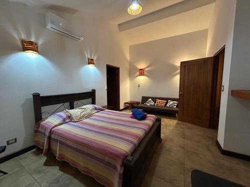 a bedroom with a bed and a couch at Beach house between Tamarindo and Avellanas in Santa Cruz