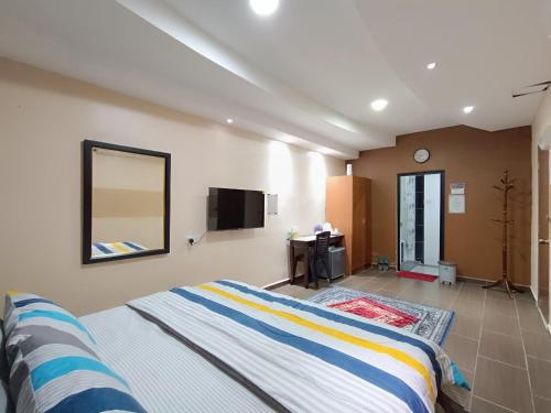 a bedroom with a bed and a tv on the wall at Al Funduq Motel in Jitra