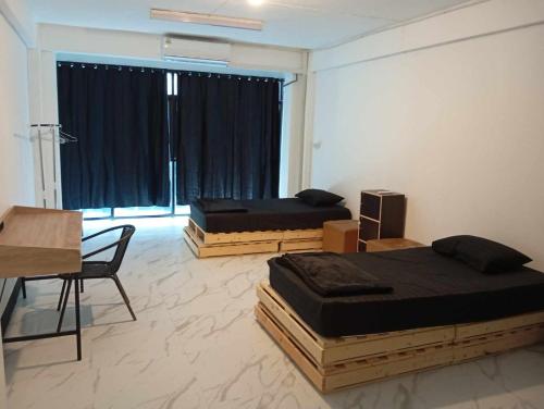 una stanza con due letti, un tavolo e una scrivania di Lita Guesthouse a Chiang Mai