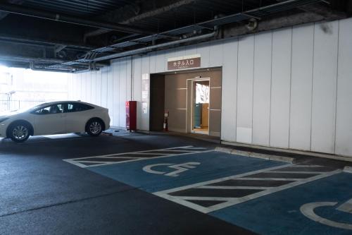a car parked in a parking lot in front of a building at Hotel Terrace the Garden Mito in Mito