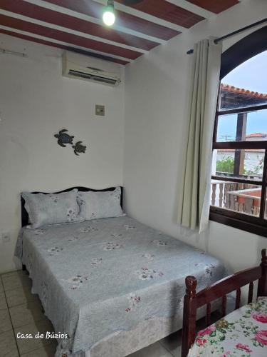 a bedroom with a bed and a window at Pousada Casa de Buzios in Búzios
