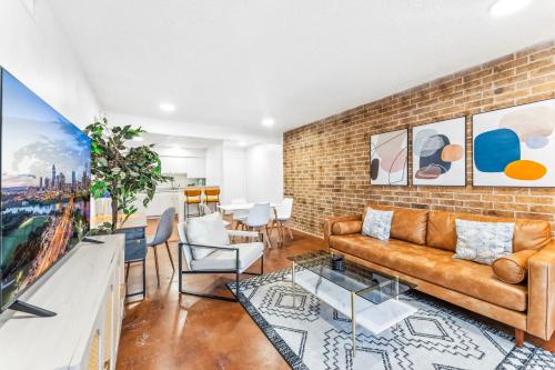 a living room with a couch and a brick wall at Heart of SoCo 2BR and 1BR King Suites with Free Parking, Pool, and Laundry Center in Austin