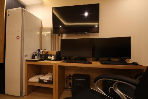 a desk with two computer monitors on top of it at Hotel Prima Busan in Busan