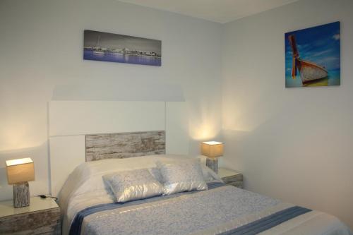 a bedroom with a bed and two pictures on the wall at Ventur Flat in Caniço