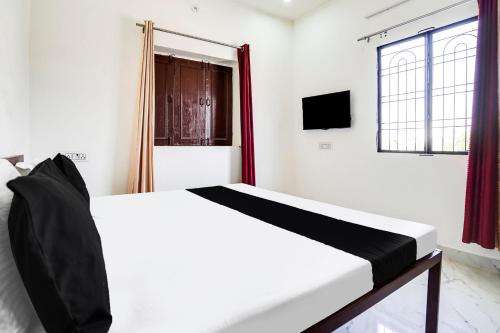 Una cama blanca en una habitación con ventana. en Hotel O The Moon, en Bareilly