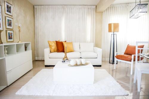 a living room with a white couch and a table at Residencial Nany in San Felipe de Puerto Plata