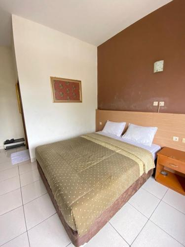 a bedroom with a large bed and a table at Handayani Hotel in Sumedang Utara