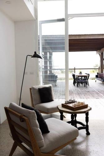 a living room with two chairs and a table at THE BEACH HAVENS in Emerald Beach
