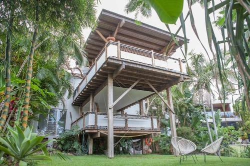 a building with a balcony and chairs in the grass at THE BEACH HAVENS in Emerald Beach