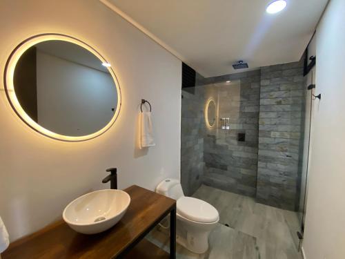 a bathroom with a sink and a toilet and a shower at Epic Suites x Ahead in Pereira
