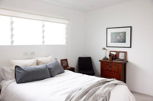 a bedroom with a bed and a chair and a window at THE BEACH HAVENS in Emerald Beach