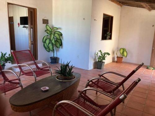 a patio with chairs and a wooden table and a table and chairs at Casa Flor Morena in Aracati