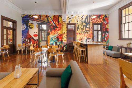 a room with a colorful wall with tables and chairs at Pullman Reef Hotel Casino in Cairns