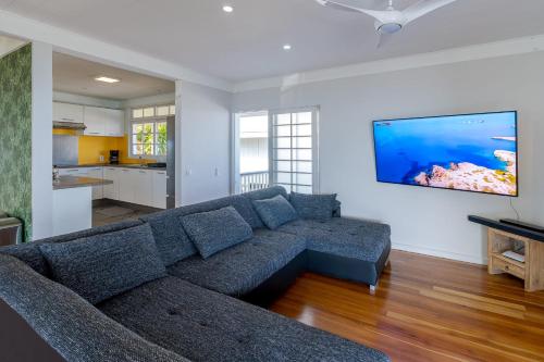 a living room with a couch and a television on a wall at Domaine To'a Hotu in Tohautu