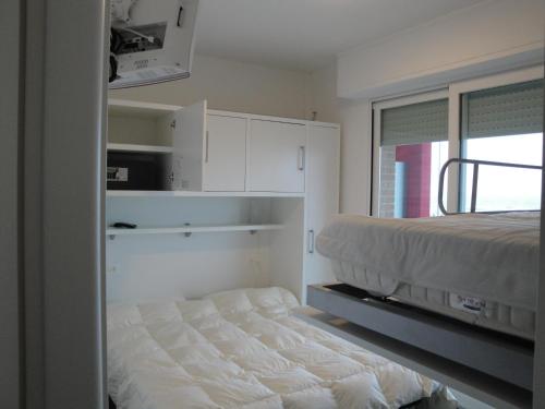 a bedroom with a bed and white cabinets and a window at Residence La Nave in Senigallia